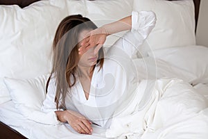 Sleepy millennial woman suffering from bad sleep waking up