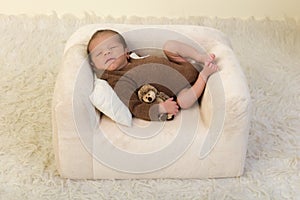 Sleepy newborn on white couch