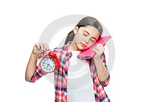 sleepy school girl with alarm clock in studio. school girl with alarm clock on background.