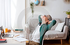 Sleepy schooler sitting in front of laptop and stretching