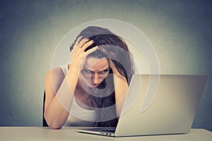 Sleepy stressed young woman sitting at her desk in front of computer