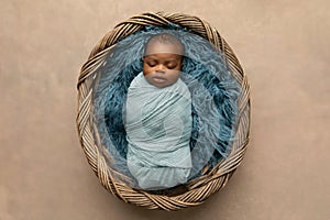 Sleepy swaddled African-American newborn baby boy