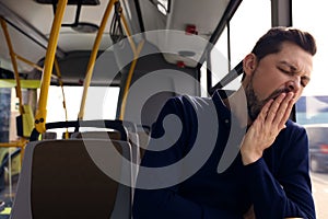 Sleepy tired man yawning in public transport