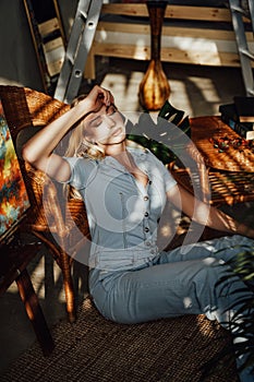 Sleepy woman with blond hairs relaxing on carpet