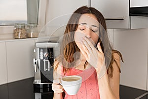 Sleepy woman in the morning drinking coffee