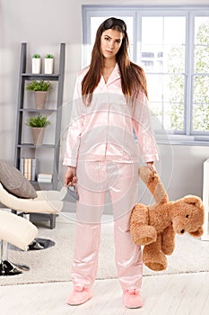 Sleepy woman in pyjama with teddy bear