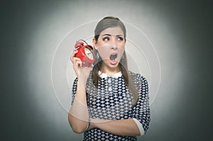 Sleepy woman with red alarm clock on gray background.
