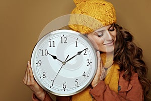 Sleepy woman with round clock remind about autumn time change