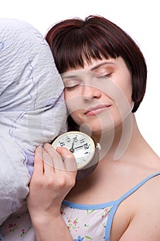 Sleepy woman is sleeping and holding alarm clock