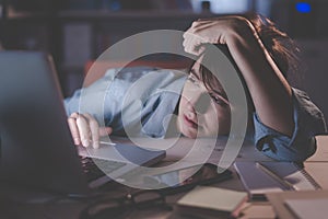 Sleepy woman working with her laptop