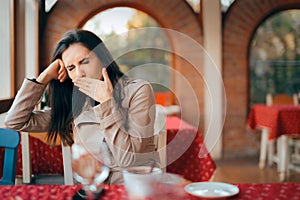 Sleepy Woman Yawning while Waiting In a Restaurant