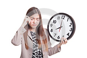 Sleepy young Asian woman with a clock in the morning.