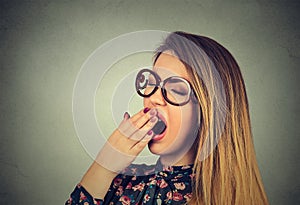 Sleepy young woman with wide open mouth yawning