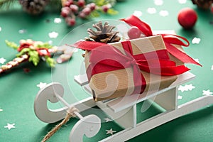 Sleigh with Christmas presents and winter decorations, green background