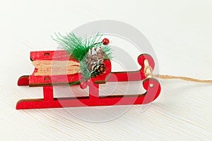 Sleigh of santa claus with fir-tree cones and green spruce branches against a background of white wood with gold veins