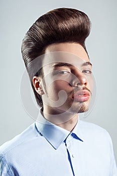 Slelf-confident man with mustache with retro pompadour hairstyle, looking with serious expression.