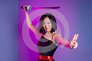 slender Asian woman in a black dress with a katana in her hand image of a samurai on a neon background