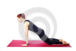 A slender athletic girl does push-ups from her knees on a gym mat.Exercises for the development of the pectoral muscles