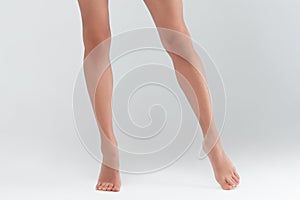 Slender beautiful female legs on white background