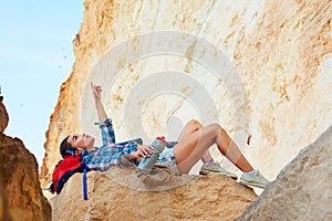 Slender climber lay down to rest on top of a cliff.