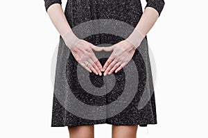 Slender girl in a dark dress experiences discomfort in the uterus, pain, hands between her legs. Incontinence, need to pee in the