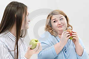 Slender girl eats healthy food, Fat woman eats harmful fast food. On a white background, the theme of diet and proper