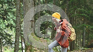 Slender girl goes along the path to the top in the coniferous forest. Tourism in the Caucasus Reserve. Will approach the