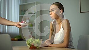 Slender girl prefers salad instead of cake, vegetarian meal, low-calorie food