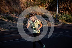 Slender girl in sportswear is jogging, holding smartphone in hands. Business woman talking on phone