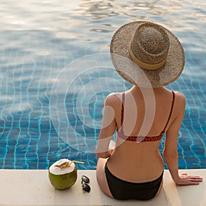 Slender girl sunbathes near the swimming pool.