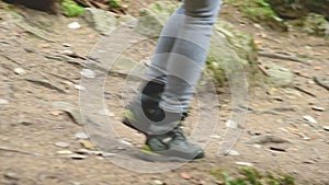 Slender girl walking along the path in the coniferous forest. Tourism in the Caucasus Reserve. Closeup of a tourist`s