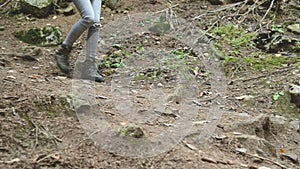 Slender girl walking along the path in the coniferous forest. Tourism in the Caucasus Reserve. Closeup of a tourist`s