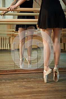 Slender legs dancers near Barre