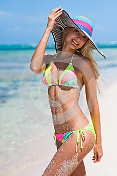 Slender lovely blonde posing on a tropical beach in the Dominican Republic. A girl in a bikini.