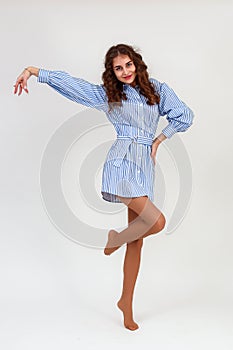 Slender smiling beautiful young woman on a white background