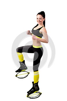 Slender smiling girl in kangoo jamps shoes doing exercises,