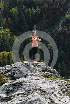 A slender woman does yoga exercises against an incredible backdrop of nature. The woman does yoga in the fresh air.