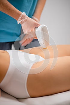 Slender woman get hair removal procedure on legs