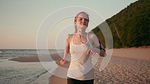 Slender Woman Runner is Jogging on the Beach at Sunset or Sunrise at Sea Coast