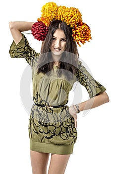 Slender young cheerful girl brown hair dances with a bouquet of colorful flowers on her head