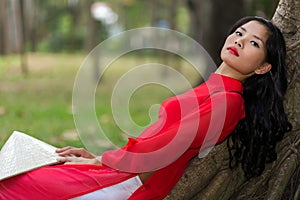 Slender young Vietnamese woman relaxing in a park