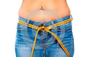 slender young woman in jeans with a tape measure after a succe