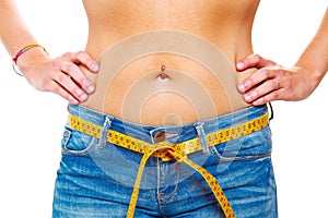 slender young woman in jeans with a tape measure after a succe