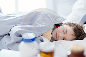 Slepping sick child hugging a teddy bear