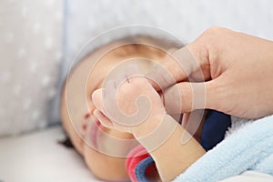 Slept baby hand holding mother finger