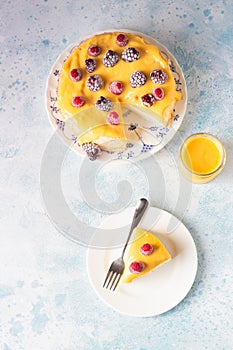 Slice of angel food cake with lemon curd and frozen berries raspberry and blackberry.