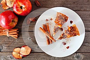 Slice of autumn caramel apple pecan cheesecake, top view table scene over wood