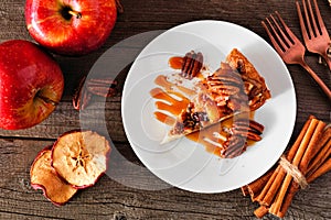 Slice of autumn caramel apple pecan cheesecake, top view table scene over wood