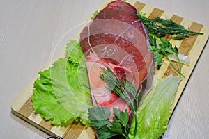 Slice of beef with herbs on a wooden board. photo