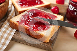 Slice of bread with delicious strawberry jam on board, closeup